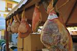 Hams hanging to dry at market stall during Medieval Festival in Plaza de la Corredera