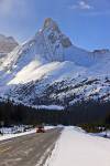 Stock photo of a smart car alone on a snowy road, the Icefield Highway and dwarfed by Hilda Peak as viewed from the Icefields Parkway in Banff National Park, Canadian Rocky Mountains, Alberta, Canada.