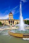 Stock photo of the Legislative Building and fountain against a deep blue sky in the Manitoba Plaza in the City of Winnipeg, Manitoba, Canada.