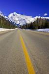 Stock photo of Yellowhead Highway (16) in winter leading towards the snow-capped Mount Robson against a deep blue sky in Mount Robson Provincial Park, British Columbia, Canada.