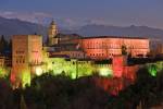 Stock photo of The Alhambra (La Alhambra) a moorish citadel and palace designated a UNESCO World Heritage Site in 1984, backdropped by the snowcapped Sierra Nevada mountain range seen from Mirador de San Nicolas in the Albayzin district at dusk, Granada.