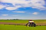 Stock photo of a farmer spraying crops by tractor near the town of Rockglen, Southern Saskatchewan, Canada.