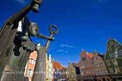 Bronze statue of jester back dropped by colorful facades of buildings in Old Town district Landshut