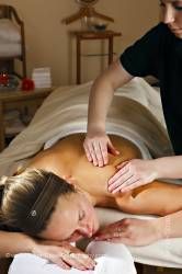Masseuse giving a woman shoulder and back massage