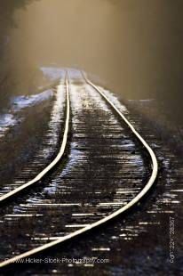 Stock photo of the fog hovering above railway tracks with  a light covering of snow on the ground in the late afternoon sunlight near Beaver Cove during winter, Northern Vancouver Island, Vancouver Island, British Columbia, Canada.