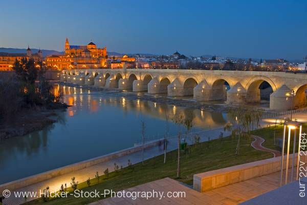 Stock photo of Puente Romano bridge spans Rio Guadalquivir to Mezquita at dusk in City of Cordoba Andalusia