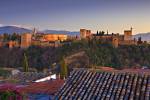 Stock photo of The Alhambra (La Alhambra) a Moorish citadel and palace designated a UNESCO World Heritage Site in 1984, back dropped by the snow capped Sierra Nevada mountain range seen from Mirador de San Nicolas in the Albayzin district at dusk, City of