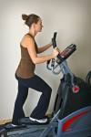 Stock photo of a woman working out on an elliptical trainer in the exercise room at the Black Bear Resort & Spa, Port McNeill Northern Vancouver Island, Vancouver Island, British Columbia, Canada.