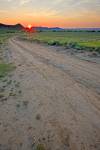Stock photo of farmland and a dirt road in the Big Muddy Badlands at sunset, Southern Saskatchewan, Canada.