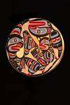 Stock photo of a handmade wooden drum by Trevor Hunt, First Nations Artist, featuring Wildman (Pugwis) and the Killer Whale. This piece is on display at the Just Art Gallery in Port McNeill, Northern Vancouver Island, British Columbia, Canada.