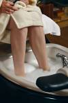 Stock photo of a woman soaking her feet in a foot spa during a pedicure treatment.