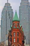 Stock photo of the red and green Gooderham building in front of two skyscarpers in downtown Toronto, Ontario, Canada.