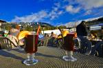 Stock photo of glasses of hot gluehwein (mulled wine) served at the Longhorn Saloon and Grill an apres-ski bar at the base of Whistler Mountain, Whistler Village, British Columbia, Canada. A bright blue sky with few clouds provides a lovely background to 