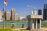 Stock photo of navy memorial in Dieppe Gardens, the Detroit River and the skyline of Detroit, Michigan in the background.