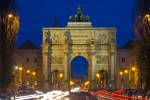 Stock photo of the Siegestor (Victory Gate) with traffic flowing around it at dusk in the Schwabing district in the City of Mnchen (Munich), Bavaria, Germany, Europe.