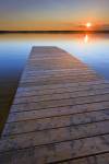 Stock photo of the golden sunset seen from the wooden wharf at Lake Audy, Riding Mountain National Park, Manitoba, Canada.