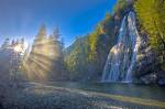 Stock photo of the Virgin Falls plunging 53 metres/174 feet in a fan formation down a rock escarpment along the Tofino Creek with rays of sunlight streaming through the trees, a transition area of the Clayoquot Sound UNESCO Biosphere Reserve, Vancouver Is