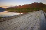 Stock photo of an old wooden bridge spanning the entrance to Clayoquot Arm of Kennedy Lake at sunset, a transition area of the Clayoquot Sound UNESCO Biosphere Reserve, Vancouver Island, British Columbia, Canada.
