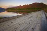 Stock photo of an old wooden bridge spanning the entrance to Clayoquot Arm of Kennedy Lake at sunset, a transition area of the Clayoquot Sound UNESCO Biosphere Reserve, Vancouver Island, British Columbia, Canada.