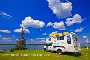 Stock photo of a camper with a view of Lake Audy at the Lake Audy Campground in Riding Mountain National Park, Manitoba, Canada.