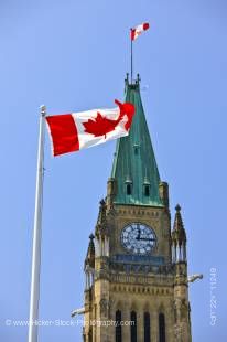 Stock photo of a Canadian flag in front of the upper part of the Peace Tower on Parliament Hill, Ottawa, Canada
