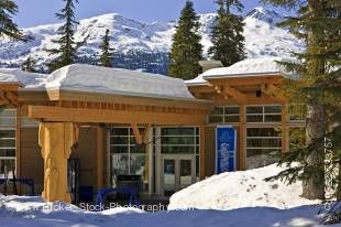 Stock photo of the Day Lodge at the Whistler 2010 Olympic Park Nordic Sports Venue in Callaghan Valley, British Columbia, Canada. Deep snow covers the ground, the lodge, and the mountains above in this winter scene that also includes several tall evergree