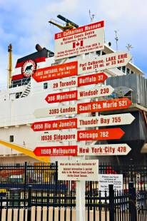 Stock photo of red and white sign post pointing towards various destinations around the world at the St Catharine’s Museum, Lock 3, Welland Canals Centre, St. Catharine’s, Ontario, Canada.