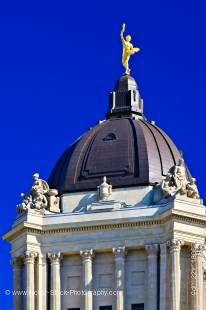 Stock photo of the Golden Boy statue crowning the dome atop the Manitoba Legislative Building against a clear and bright deep blue sky in the City of Winnipeg, Manitoba, Canada.