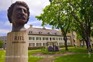 Stock photo of a monument showing a head bronze of Louis A Riel and the Saint Boniface Museum in Winnipeg, Manitoba, Canada.