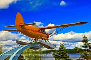 Stock photo of an orange Norseman aircraft suspended on a pedestal in the Norseman Heritage Centre Park in the town of Red Lake, Ontario, Canada.