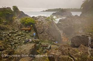 Stock photo of a rocky landscape leading to the geothermal hot springs.  Clothing lay on the rocks while several people enjoy bathing in the warm pools at Hot Springs Cove, Openit Peninsula, Maquinna Marine Provincial Park.
