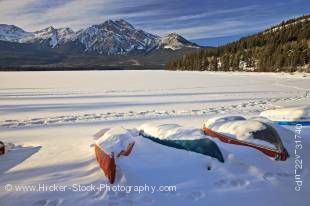 Stock photo of snow covered dinghies and canoes on the shores of Pyramid Lake near the town of Jasper in Jasper National Park in the Canadian Rocky Mountains in Alberta, Canada.