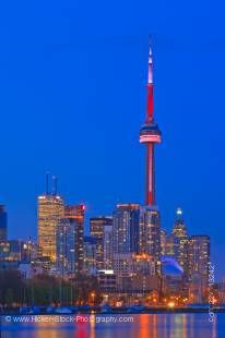 Stock photo of the skyline of Toronto illuminated at dusk with high rise buildings and CN Tower.