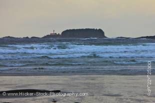 Stock photo of the stormy waves of the Pacific Ocean at the beach in Cox Bay near Tofino with the Lennard Island Lighthouse in the background, a transition area of the Clayoquot Sound UNESCO Biosphere Reserve, West Coast, Vancouver Island, British Columbi