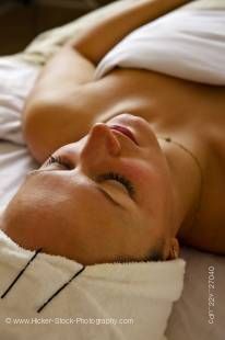 A stock photo of a young woman with her eyes closed during a relaxing facial treatment.