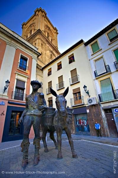 Stock photo of Man and donkey statue Plaza de la Romanilla and bell tower of Cathedral City of Granada